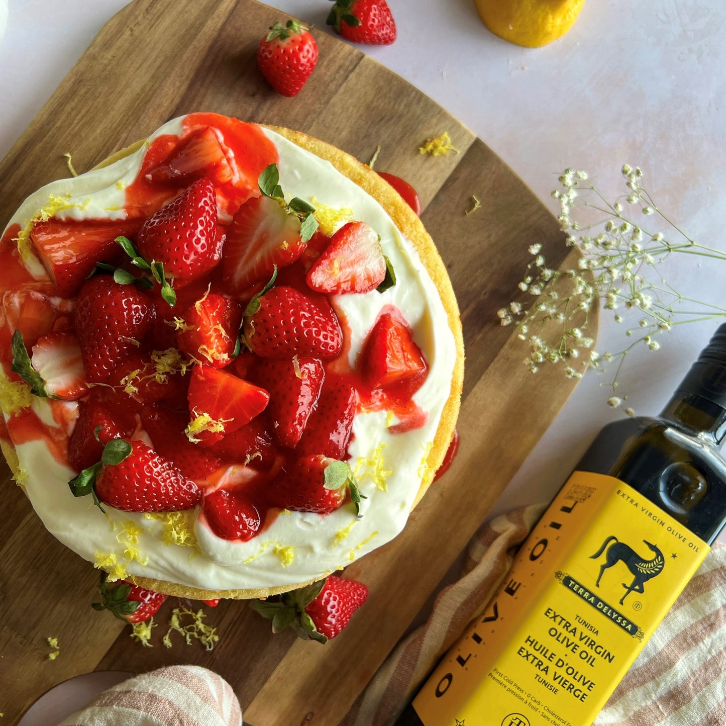 Our images of this delectable cake showcase its moist and tender crumb, with golden edges that hint at the delicious flavor inside. You can almost taste the sweet aroma of the cake, with its enticing blend of lemon and olive oil. The strawberries on top add a pop of color and freshness that perfectly balance out the rich flavors of the cake.